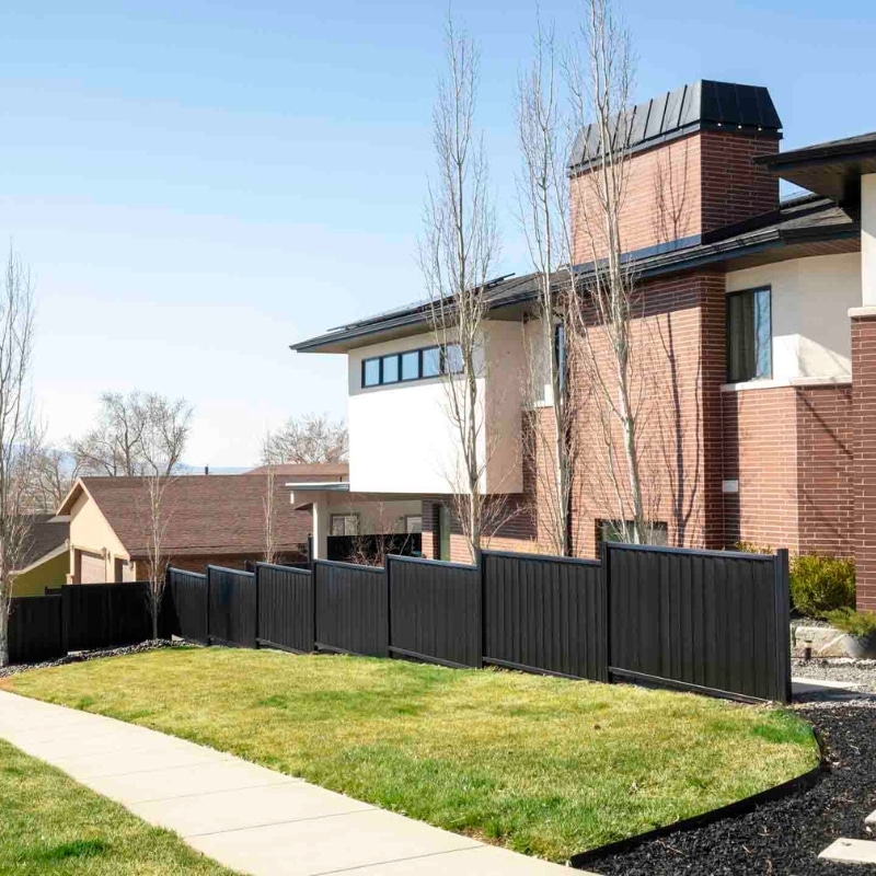 A row of dark color ColorMax fence panels in front of a house, a perfect option for Bel Air Knolls, Goleta non-combustible fences.