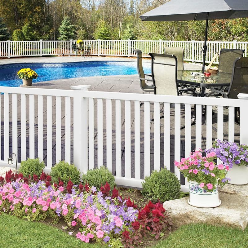 A white closed picket fence surrounding a swimming pool, an example of our vinyl fencing near Betteravia, Santa Maria, California.