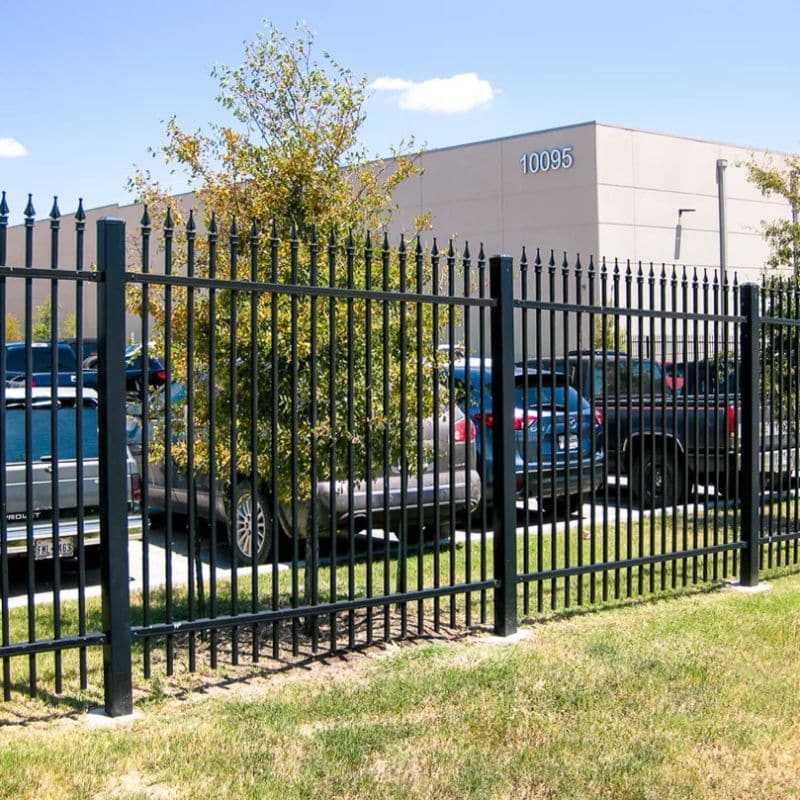 Los Alamos wrought iron fencing in front of a parking lot and commercial property.